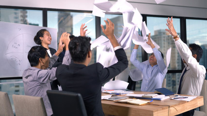 Business team throwing paper when meeting success