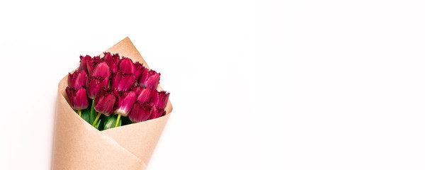 8 March, International Women's Day. Bouquet of red tulips wrapped in craft paper on white background with space for text