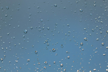 Rain drops on a window against a thundery gray sky