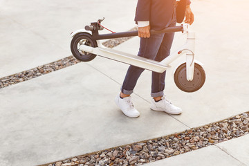Crop guy carrying modern scooter © kegfire