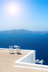 Two chairs on the terrace with sea view. Santorini island, Greece. Travel destinations concept