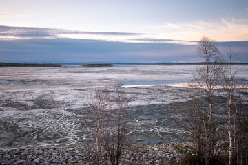 Obraz premium Stones on the White Sea coast at sunset. Frozen water, summer, white nights.