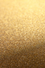Golden glitter shiny background with selective focus. New Year or Christmas wrapping holiday paper texture, vertical format