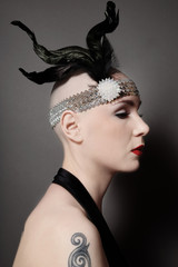 Vintage style portrait of skinhead woman with red lips and fancy headband on her head