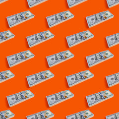 Seamless pattern of stack of hundred dollars on orange background