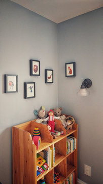 Kids room corner with book case and framed pictures