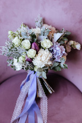Rich bunch of pink peonies and lilac eustoma roses flowers, green leaf in glass vase. Fresh spring bouquet. Summer Background