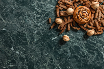 Bun with raisins, walnut cookie, rye crackers view from above marble