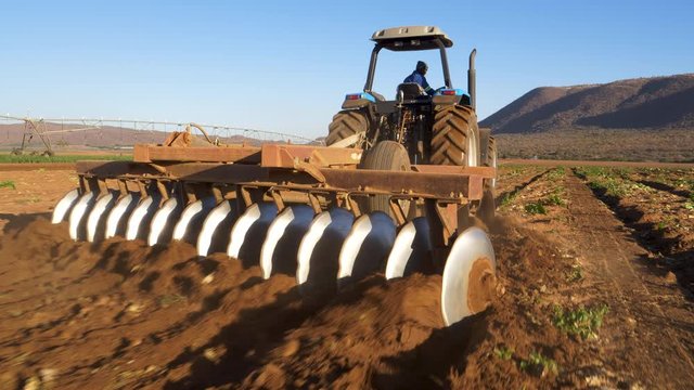Close-up rear view of the plough discs on the back of a tractor ploughing fields on a large scale farm
