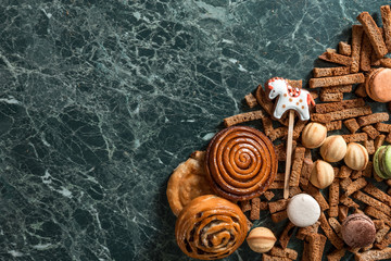cinnamon bun, cookie, walnut, rye crackers, macarons view from above on marble