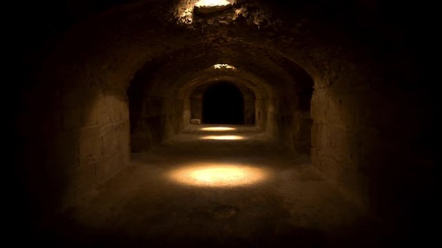 Pass through a long and dark Roman basement. Basement under the amphitheater in El Jem, Tunis. Ancient roman building. The camera is approaching