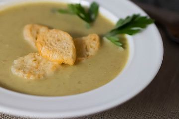 Cream of vegetable soup in a white bowl on a gray background.