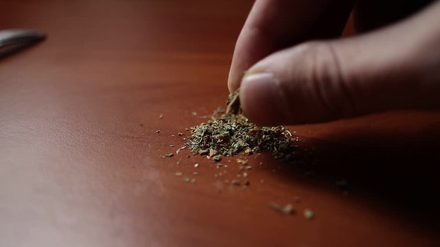 marijuana on the table, preparing to twist the jamb