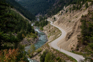Aerial View of a Scenic Dirt Road towards Gold Bridge in the Valley surrounded by Canadian Mountain Landscape. Taken near Lillooet, British Columbia, Canada.