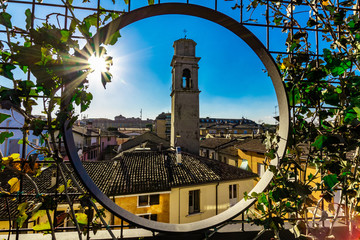 A small church (Chiesa del santo Crocifisso) in the typical mediterrean town desenzano in italy with beautiful sky and sunrays