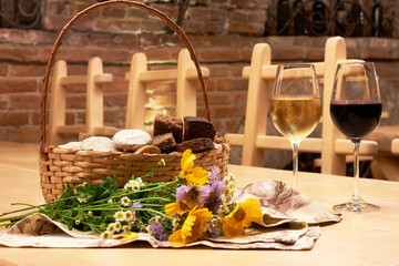Still life with two glasses with red and white wine on wooden table in the old vintage wine cellar from red brick