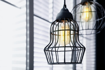 Obraz premium Stylish metallic pendant lamp with Edison light bulb indoors