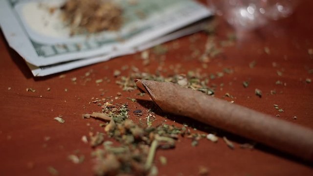 marijuana on the table, preparing to twist the jamb