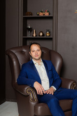 Obraz premium Serious businessman in a leather armchair and premium interior.