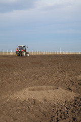 Fototapeta premium Drilling holes in field, preparing for tree planting