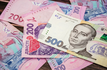 Ukrainian money on a wooden background. 200 and 500 hryvnia.