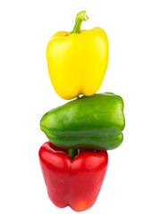 Assorted paprika on a white background. Tower of three peppers. Three bell peppers arranged one on one. Green yellow and red peppers on a white background.