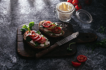 Whole grain bread bruschetta with cream cheese and cherry tomatoes