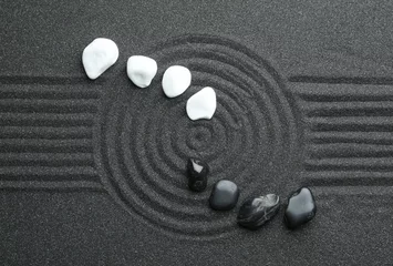 Dekokissen Steine auf schwarzem Sand mit schönem Muster, flach gelegt. Zen und Harmonie © New Africa