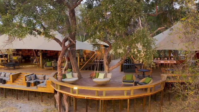 Close-up aerial panning view of the outside deck area and boma at Tuludi Safari Camp, Okavango Delta, Botswana