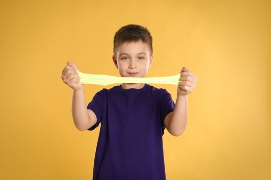Little boy with slime on yellow background