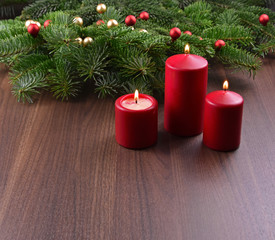 Red candles on a christmas background stock images. Christmas ornament on a Christmas tree branch. Red Christmas candles on the table. Christmas background with copy space for text