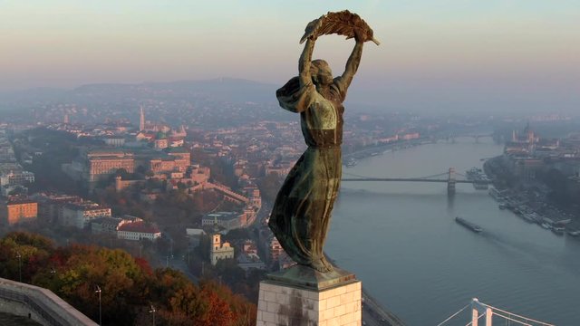 Budapest, Hungary, aerial view of historical landmark Liberty Statue and Budapest cityscape at sunrise.