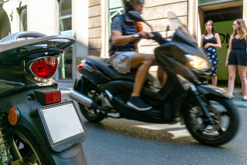Plakat Ein Mann fährt auf einem Motorroller durch die City von Mailand