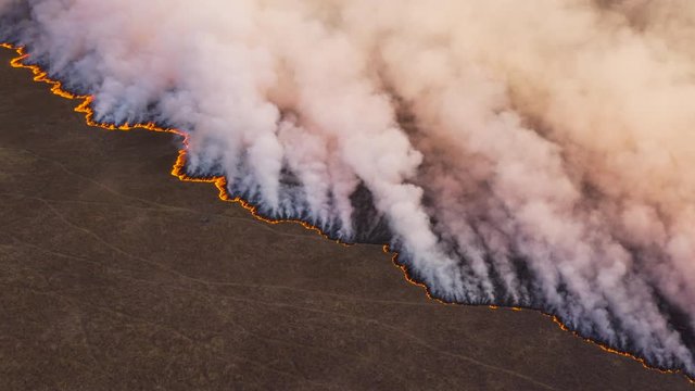 Climate change.High aerial fly over view of a grass fire in the Okavango Delta, caused by drought and climate change, Botswana