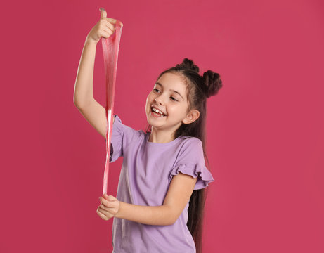 Little girl with slime on pink background