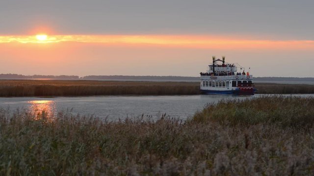 Sunset at the Dar&szlig; peninsula with a bird watching boat on the water