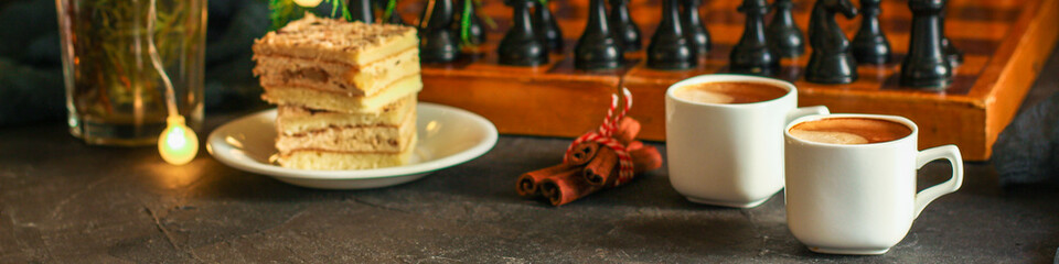 coffee, piece of cake (festive atmosphere, chess, Christmas lights, new year) menu concept. food background. top view. copy space