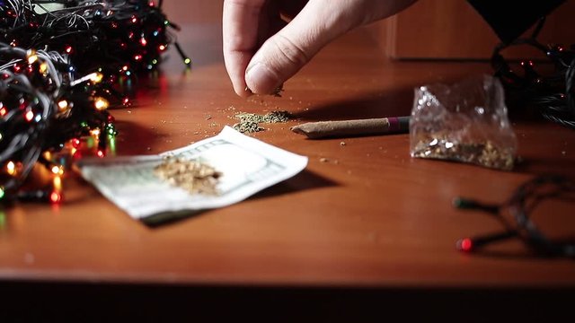 marijuana on the table, preparing to twist the jamb