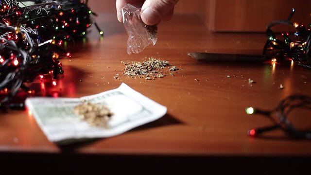 marijuana on the table, preparing to twist the jamb