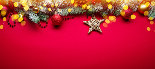 Red New Year or Christmas background with fir branch and Christmas decor.