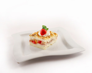 Dessert with fruits and berries on a plate, decorated with cream and strawberries