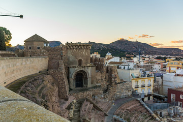 Obraz premium Aerial panoramic view of port city Cartagena in Spain with famous roman amphitheater. Beautiful sunset over the mountains. Wide angle lens panorama