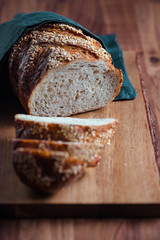 Whole grain loaf bread with chia seeds on a cutting board. Healthy eating concept.