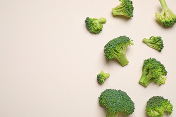 Fresh tasty broccoli on light beige background, flat lay. Space for text