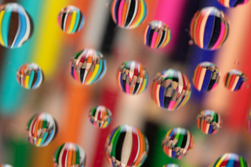 Drawing pencils reflected on waterdrops resting a piece of glass
