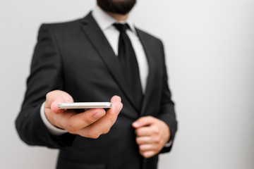 Male human wear formal work suit hold smart hi tech smartphone use one hand