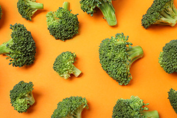 Fresh tasty broccoli on orange background, flat lay