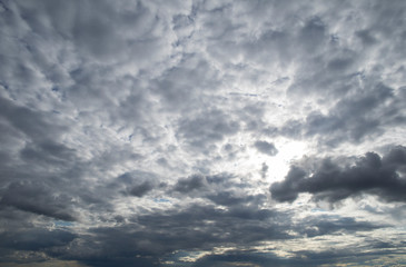 Fototapeta premium Evening contrast ominous sky with grey and white clouds and sunlights. Dramatic sky