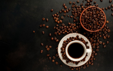 Cup of tasty coffee and beans on a stone background. Top view with copy space for your text.