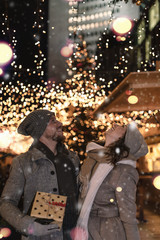 Fototapeta na wymiar christmas tree with lights and love couple in city night